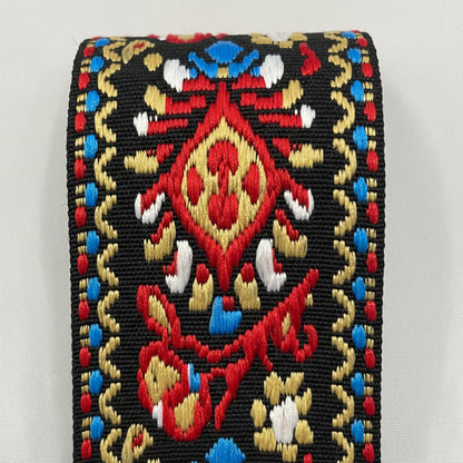 Close up of a Red, Gold and Black Embroidered Guitar Strap pattern on a white background.