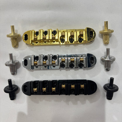 Electric guitar Roller Bridge components including gold, chrome, and black parts on a white background