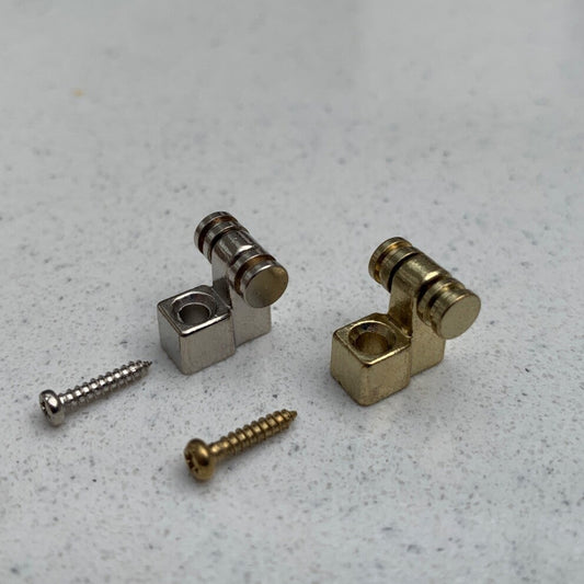 Two Roller Guitar String Tree / Retainers on a grey background.