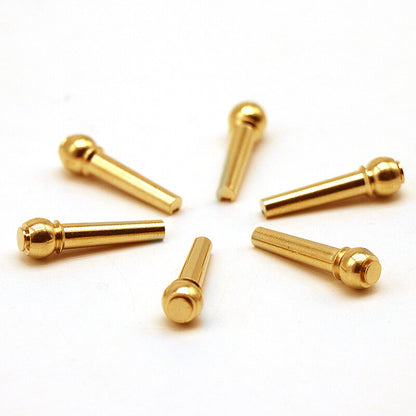 Six Acoustic Guitar Brass Bridge Pins arranged in a circle against on a white background.