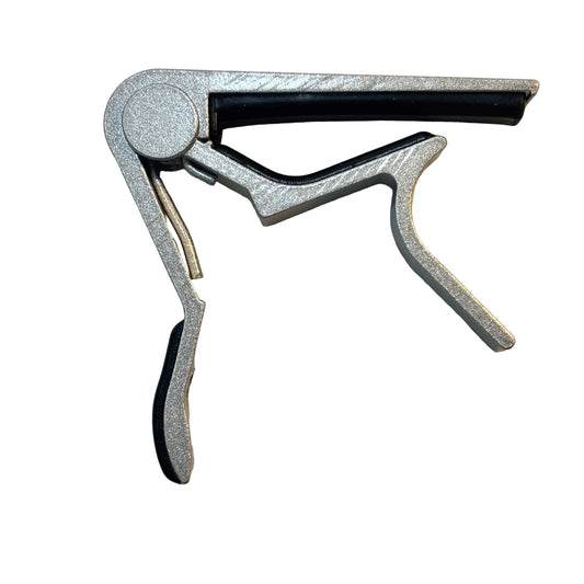 Metallic guitar capo on a white background
