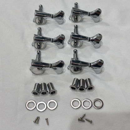 A set of six Chrome Fish Tail Button Guitar Tuners on  textured fabric background.