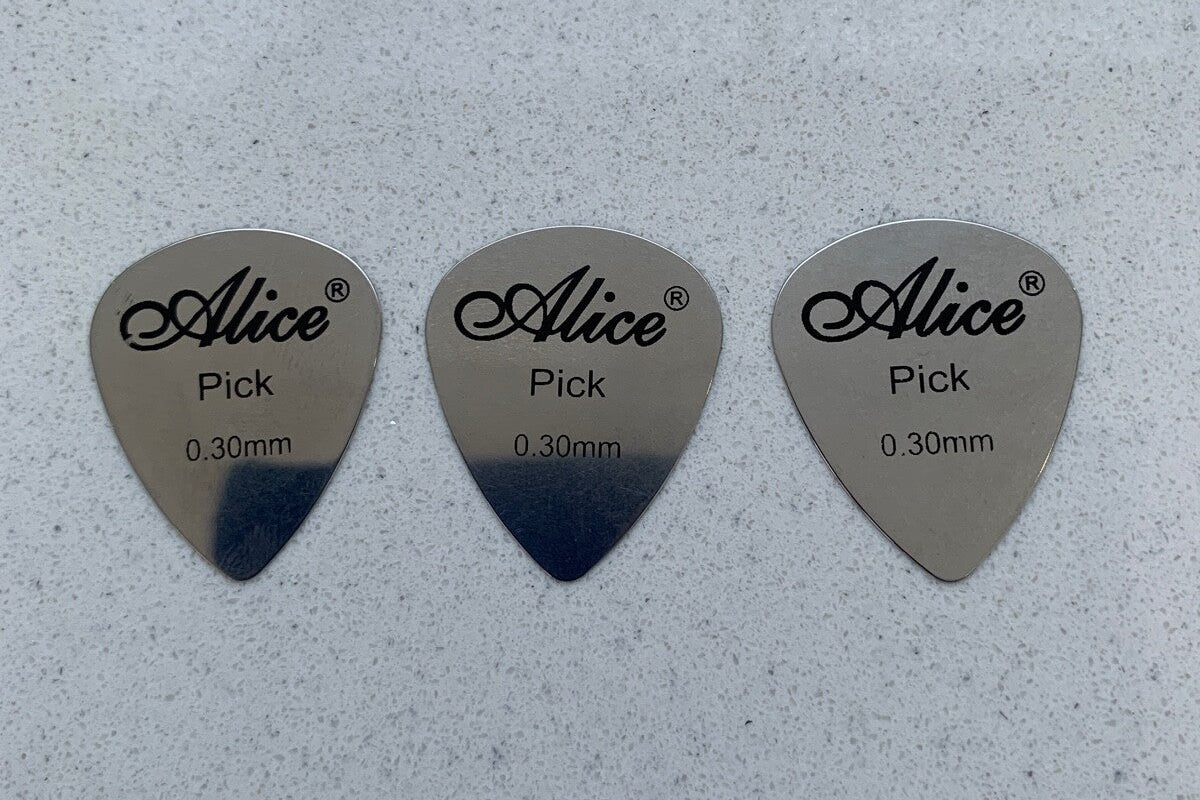 Three Alice Steel Guitar Picks Plectrums on a light grey background.