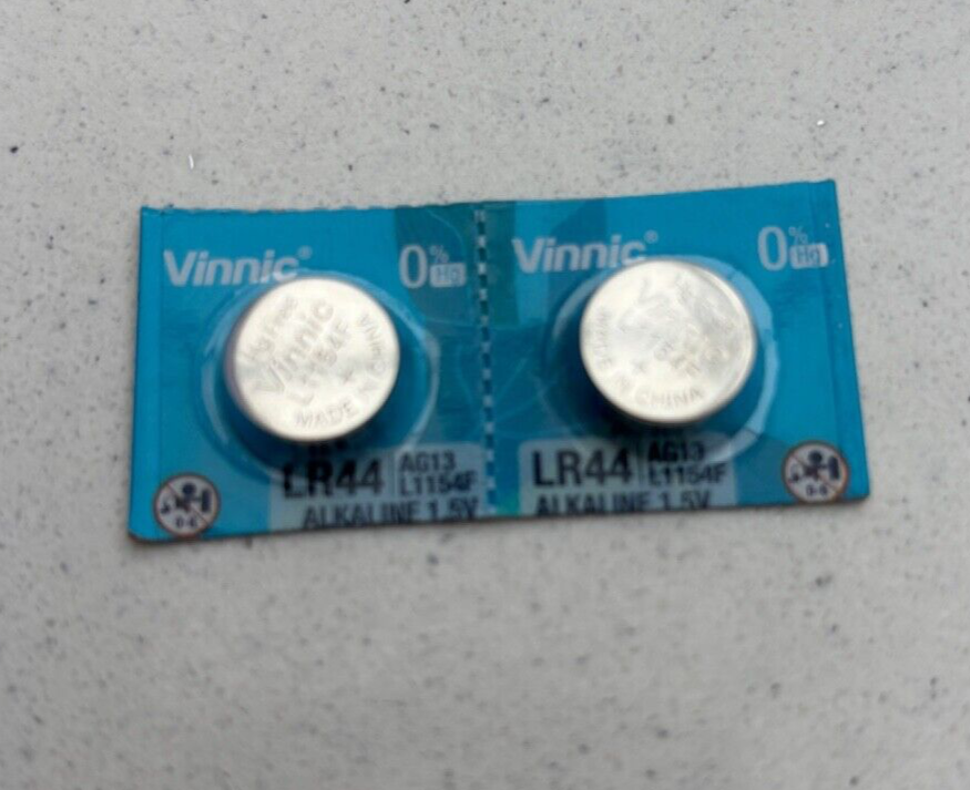 Two Vinnic LR44 batteries photographed in blue packaging against a grey background