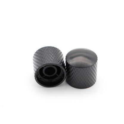 Two Black electric guitar control knobs on a white background.