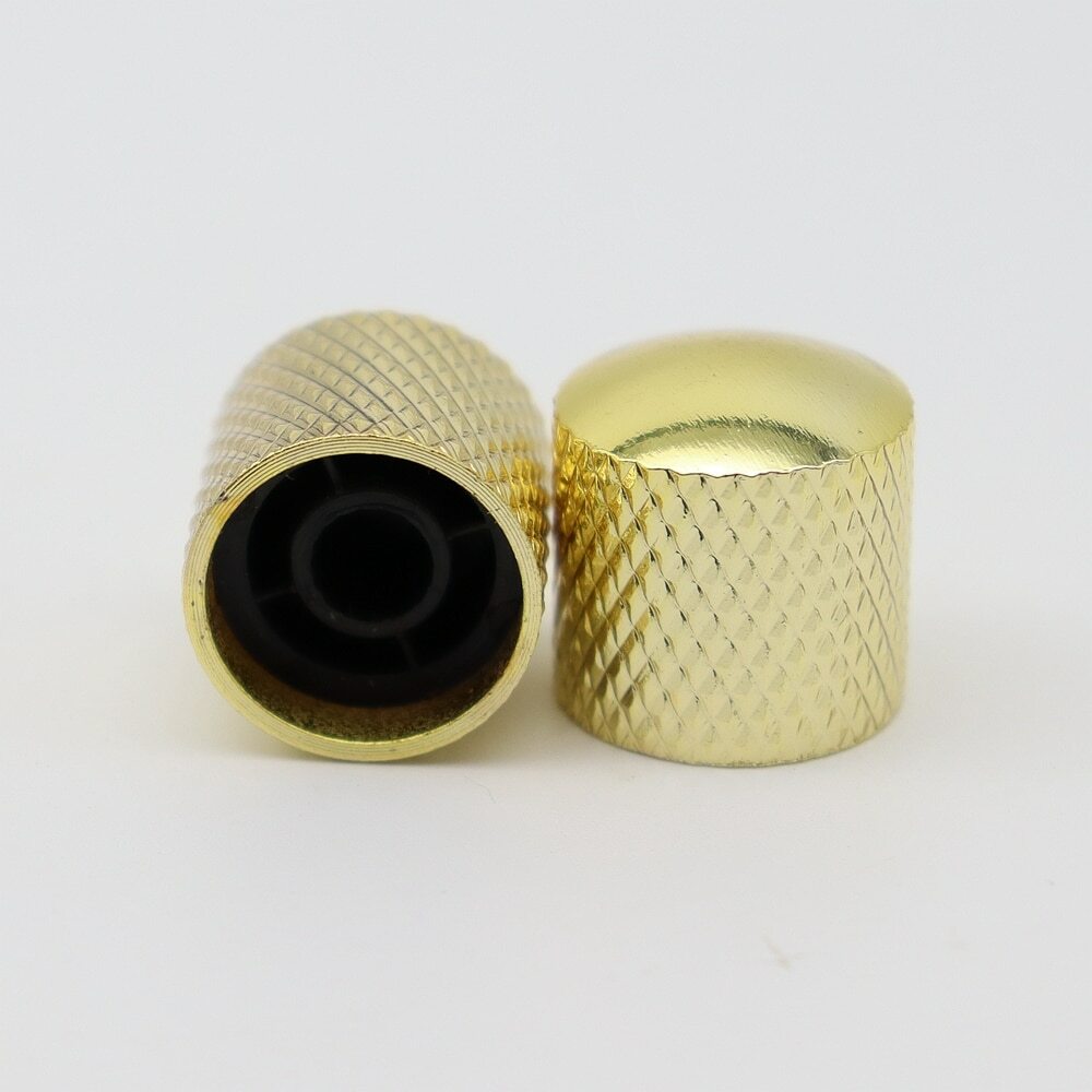 Two Gold electric guitar control knobs on a white background.