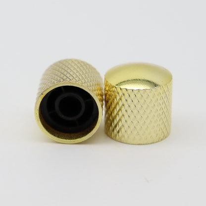 Two Gold electric guitar control knobs on a white background.