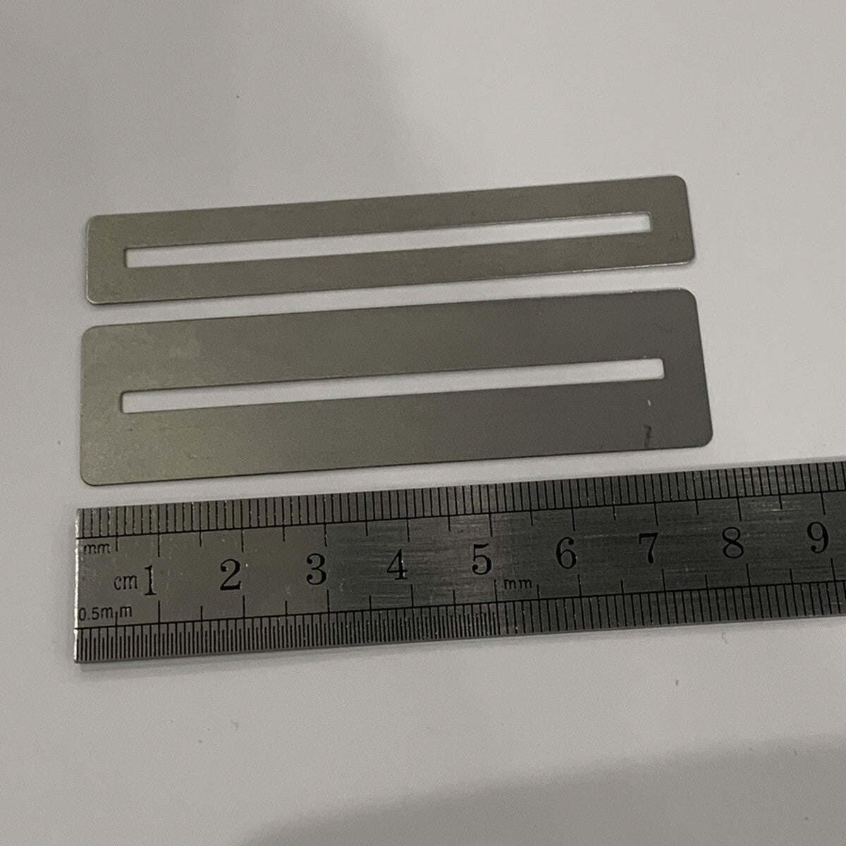 Two Guitar Fretboard Protectors/Guards photographed with a ruler for scale on a white background.