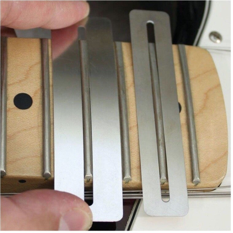 Two Guitar Fretboard Protectors/Guards held in place by fingers on a guitar fretboard.