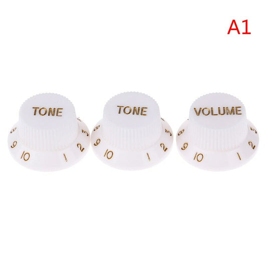 Three White electric guitar Control Knobs, ST-style, labeled 'TONE' and 'VOLUME' in Gold text on a white background.