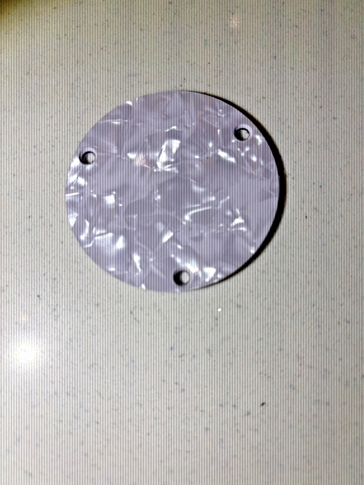 Electric Guitar Switch compartment cover in White Pearl on a grey surface.