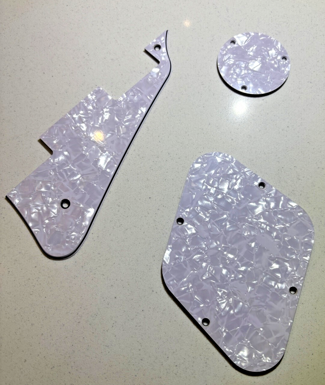 A white pearl electric guitar LP-compatible Pick Guard set on a grey background